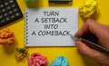 Setback or comeback symbol. Mail hand writing `turn a setback into a comeback` on white note, beautiful yellow background, color