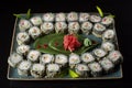 Seth sushi on a black background.Menu of the Japanese restaurant. Several sushi laid out on a plate with ginger sauce wasabi. Royalty Free Stock Photo