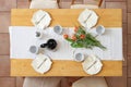 Setting for an afternoon coffee break with four plates, cups, napkins, coffee pot and tulip flowers on a white table runner on a Royalty Free Stock Photo