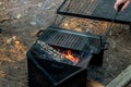 Setting the campfire in a portable foladble firepit for a camp cooking on cast iron plate Royalty Free Stock Photo