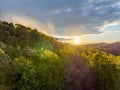 Setting over the forested landscape of Coopers Rock State Forest, with rays piercing through clouds Royalty Free Stock Photo