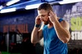 Setting the pace with his playlist. a young man listening to music during his workout at the gym. Royalty Free Stock Photo