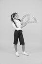 Setting square with protractor. Little girl using triangle to measure angles in degrees on yellow background. Small