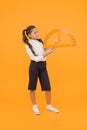 Setting square with protractor. Little girl using triangle to measure angles in degrees on yellow background. Small
