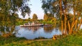 The setting summer sun illuminates the trees on the banks of the river and a tugboat passing by. Feeder rods for bream fishing are