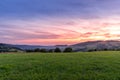 Setting sun in the Beskydy Mountains colored sky orange and blue, dark color clouds and fresh mist which formed under the mountain Royalty Free Stock Photo