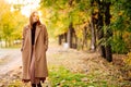 Setting sun. calm woman in coat standing on footpath in autumn Park