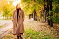 Setting sun. calm woman in coat standing on footpath in autumn Park