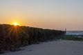 The setting sun can just be seen above the algae-covered pile heads near Westkapelle, the Netherlands