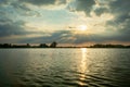 The setting sun in the clouds over the lake Royalty Free Stock Photo