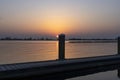 The setting sun almost disappears behind one of the bollards of a landing stage at Lake Zoetermeerse Plas in Zoetermeer, The Nethe