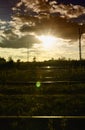 The setting sun in the evening over the railway tracks, the reflection of the light can be seen Royalty Free Stock Photo