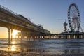 The setting sun just shines under the Pier in Scheveningen with the ferris wheel with a banner thanking our heroes in healthcare Royalty Free Stock Photo