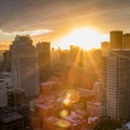 Sun peaks over the tall building of San Francisco with lots of lens flare