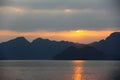 Setting sun peeking out from the clouds in Ha Long Bay, landscape view Royalty Free Stock Photo