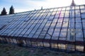 The setting sun shines over the glass roof of the greenhouse Royalty Free Stock Photo