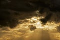 The setting sun shining through Cumulus clouds Royalty Free Stock Photo