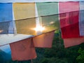 Setting sun shining through prayer flags Royalty Free Stock Photo