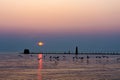 A setting sun turns the sky soft shades of pink above the Grand Haven, Michigan, pier and lighthouse