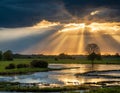 a setting sun wuth crepuscular rays setting over wet landscape - generated by ai