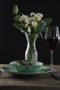 Setting a table for a dinner party with wine glass and flower vase Royalty Free Stock Photo