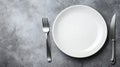 Setting a table with an empty white plate, fork, and knife on a textured gray surface in a dining area. Generative AI Royalty Free Stock Photo