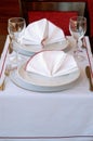 Setting the table in the restaurant with a tablecloth, silver forks, isolated knife, cloth napkins and crystal glasses. Ouerto Royalty Free Stock Photo
