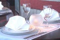 Setting the table in the restaurant with a tablecloth, silver forks, isolated knife, cloth napkins and crystal glasses. Ouerto Royalty Free Stock Photo