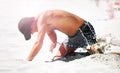 Setting up at the beach. A young man digging in the sand at the beach. Royalty Free Stock Photo