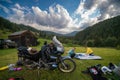 Setting up a blue tent with a great view of the mountains. A trip on a motorbike. A touring motorcycle with lots of gear. Bags,