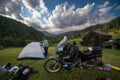 Setting up a blue tent with a great view of the mountains. A trip on a motorbike. A touring motorcycle with lots of gear. Bags,