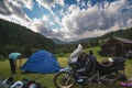 Setting up a blue tent with a great view of the mountains. A trip on a motorbike. A touring motorcycle with lots of gear. Bags,