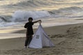 Setting up the wedding shoot, twilight on the beach with tent