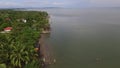 Settlement houses and establishments along tropical sandy Beach and Beautiful Calm Sea On Cloudy Day