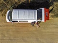 Setubal, Portugal - 30 May 2021: Aerial view of two person taking a selfie with the drone next a motorhome red and white along the