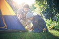 Setup first then the exploring can begin. a father and his young son putting up their tent.