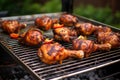 setup of jerk chicken drumsticks on a steel barbecue