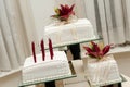 Setup of white wedding cakes with candles and fresh red stargazers on top Royalty Free Stock Photo