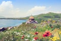 Sevanavank is sightseeing in Armenia. View of Lake Sevan, green mountains and sky. Blooming field with yellow and white flowers.