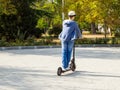 Teenager rides a scooter on paving stones