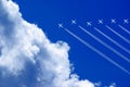 seven aeroplanes with contrails flying high in the blue sky