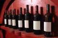 Seven bottles of wine with their own shadow resting on a wooden