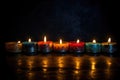 seven brightly burning candles in a kinara against a dark backdrop