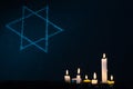 Seven burning candles and the Star of David against a black background. Royalty Free Stock Photo