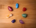 Seven Chakra gemstones in a wood surface