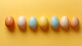 Seven colorful easter eggs placed in a row on bright yellow background top view Royalty Free Stock Photo