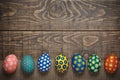 Seven colorful easter eggs on wooden background concept