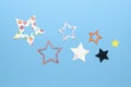 Seven colorful flat paper stars on blue background