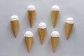 Seven cornets with vanilla ice cream on grey