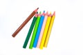 Seven different colored wood pencil crayons scattered on a white background Royalty Free Stock Photo